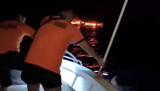 MV June Aster burns as flames and smoke rise after a fire broke out on the ferry, off the coast of Palawan