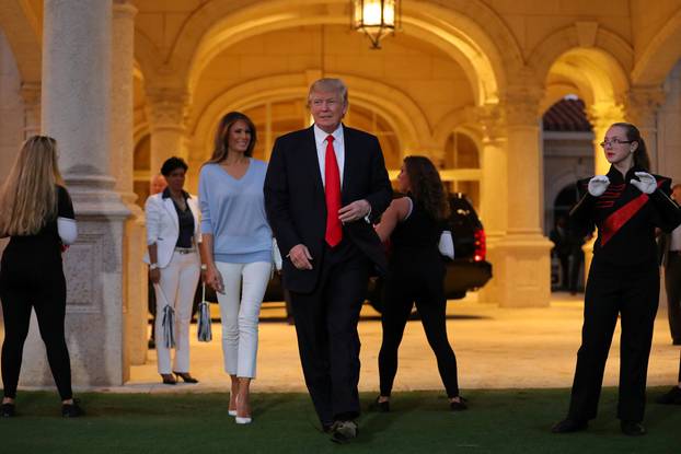 U.S. President Donald Trump and First Lady Melania Trump greet a marching band as they arrive at Trump International Golf club to watch the Super Bowl LI between New England Patriots and Atlanta Falcons in West Palm Beach, Florida, U.S.