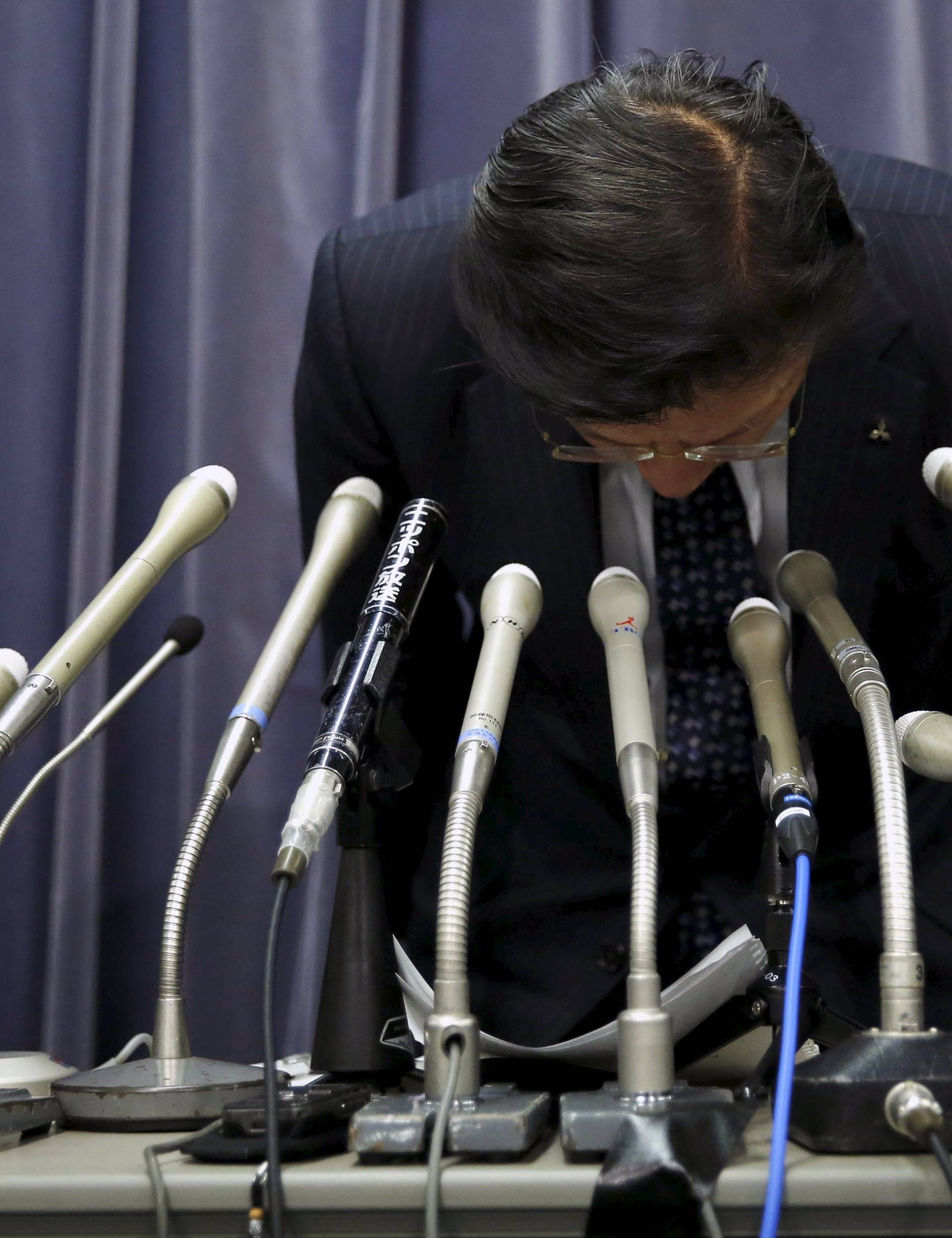 Mitsubishi Motors Corp's President Tetsuro Aikawa bows as he leaves a news conference to brief about issues of misconduct in fuel economy tests at the Land, Infrastructure, Transport and Tourism Ministry in Tokyo