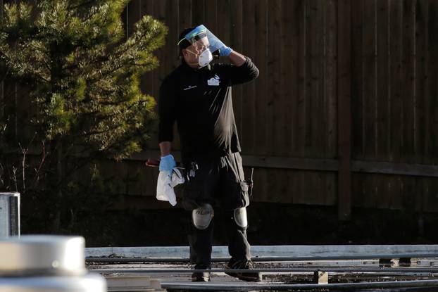 A worker talks on the phone while walking on the roof of the Life Care Center of Kirkland, the long-term care facility linked to several confirmed coronavirus cases in the state, in Kirkland