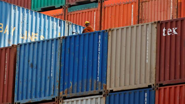 FILE PHOTO: A worker sits on a ship carrying containers at Mundra Port in the western Indian state of Gujarat