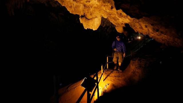 A rescue worker walks in Tham Luang caves during a search for 12 members of an under-16 soccer team and their coach, in the northern province of Chiang Rai