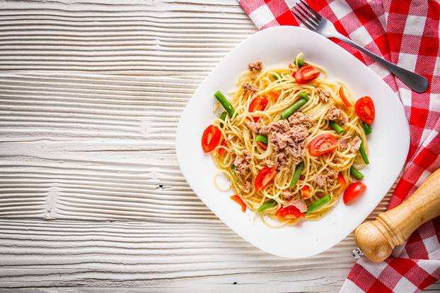 delicious traditional Italian pasta with tuna on a white rustic wooden background