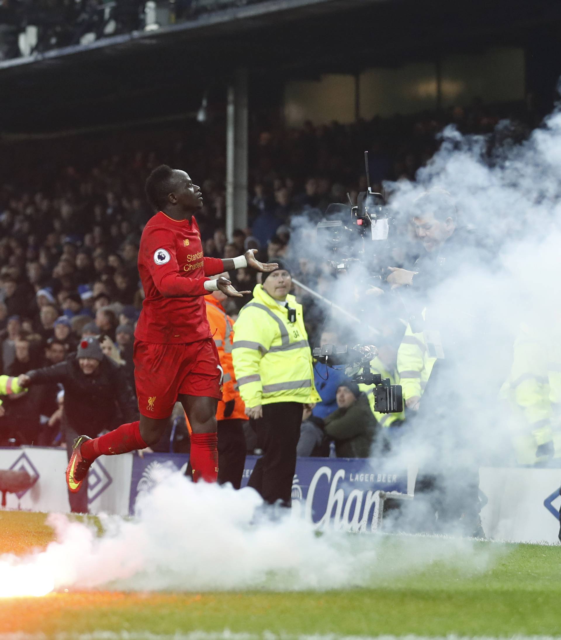 Liverpool's Sadio Mane celebrates as a flair lands on the pitch