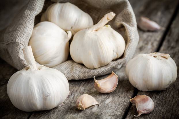 Organic garlics in the bag on a wooden table