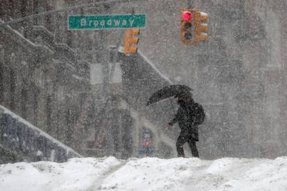 Woman walks in heavy falling snow during a winter storm in New York