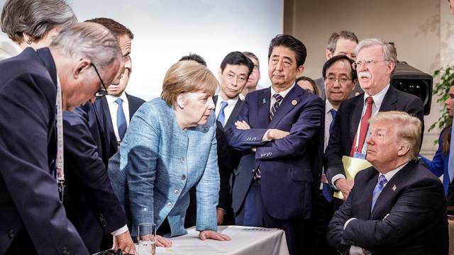 German Chancellor Merkel speaks to U.S. President Trump during the second day of the G7 meeting in Charlevoix city of La Malbaie, Quebec