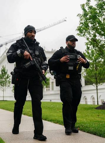 U.S. Secret Service agents walk at the White House after alleged gunshots were heard nearby, at the White House in Washington