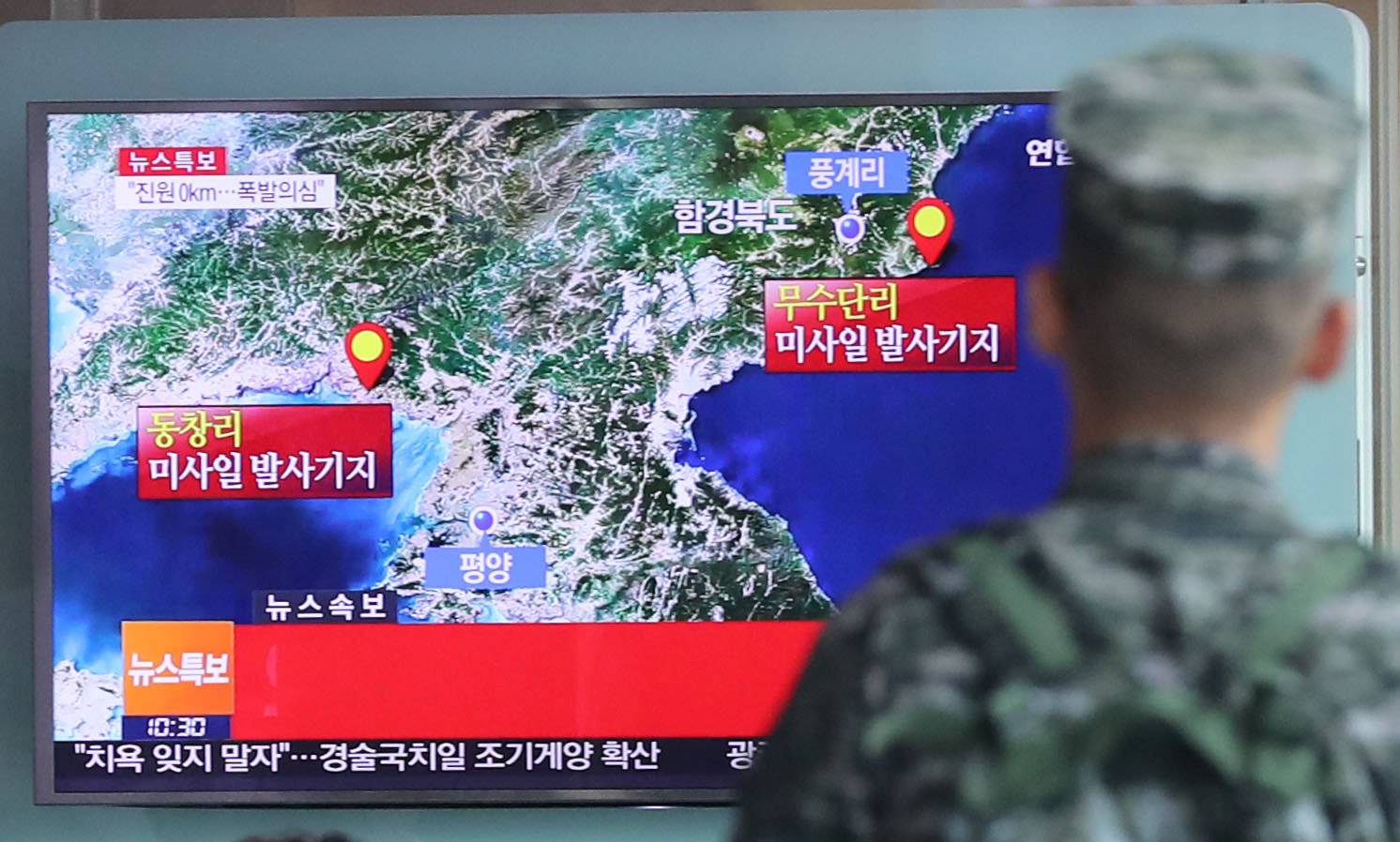A South Korean soldier watches a TV broadcasting a news report on Seismic activity produced by a suspected North Korean nuclear test, at a railway station in Seoul