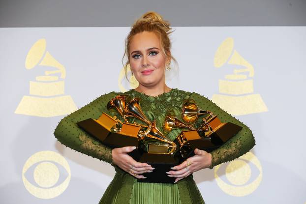 Adele holds her five Grammys during the 59th Annual Grammy Awards in Los Angeles