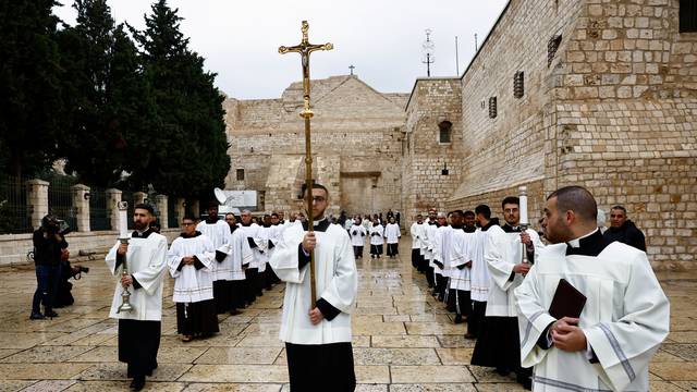 Clergy members take part in a procession on Christmas Eve outside the Church of Nativity in Bethlehem