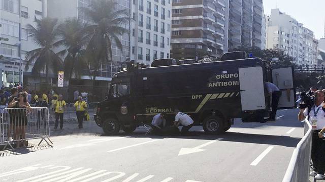 A police bomb squad inspect an unattended backpack in Copacabana Beach