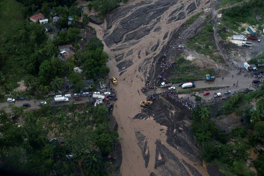 People gather next to a collapsed bridge after Hurricane Matthew passes Petit Goave, Haiti