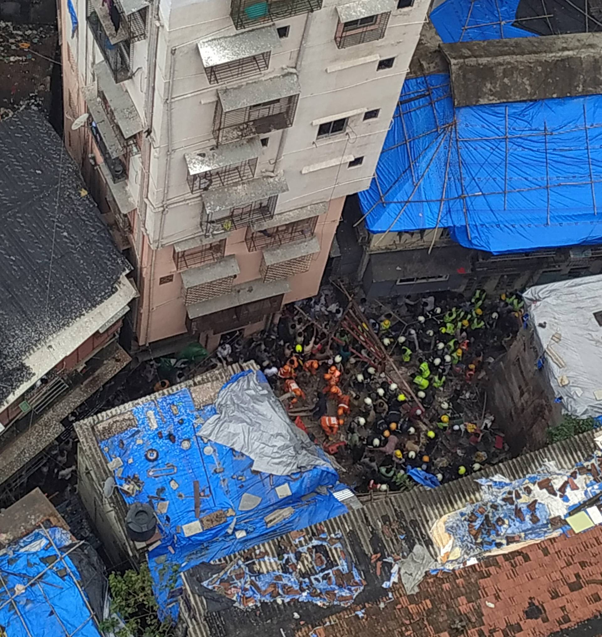 Rescue workers search for survivors at the site of a collapsed building in Mumbai