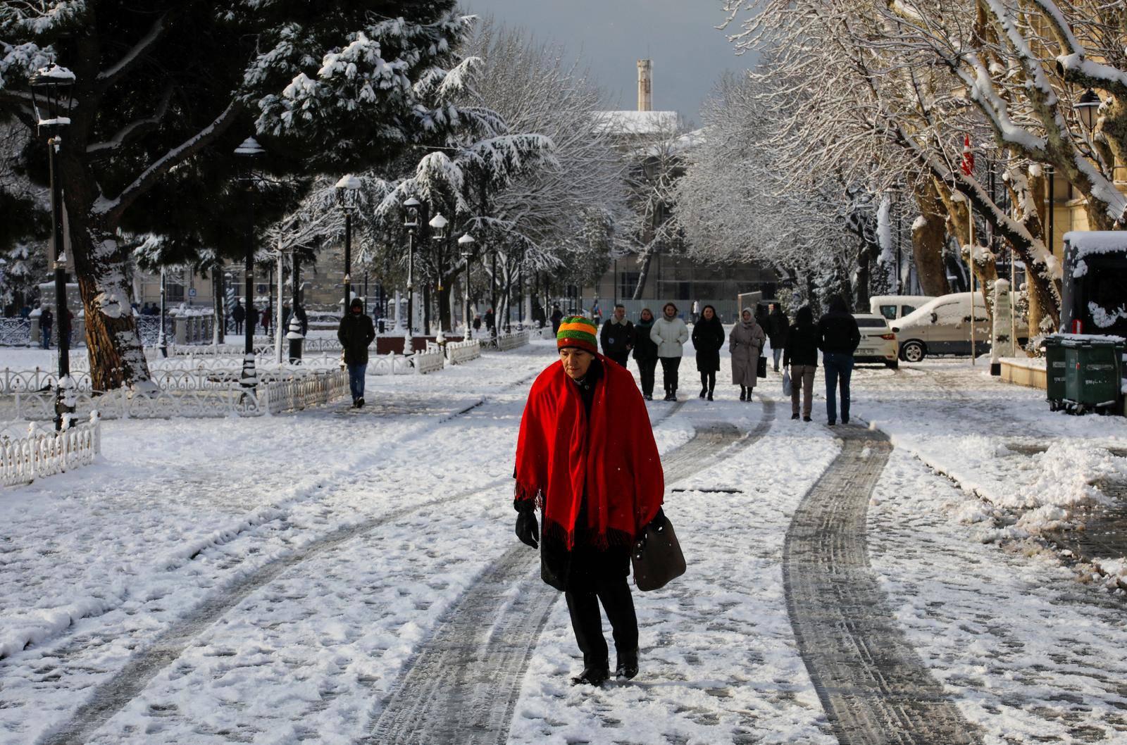 People walk through Sultanahmet Square during a snowy day in Istanbul