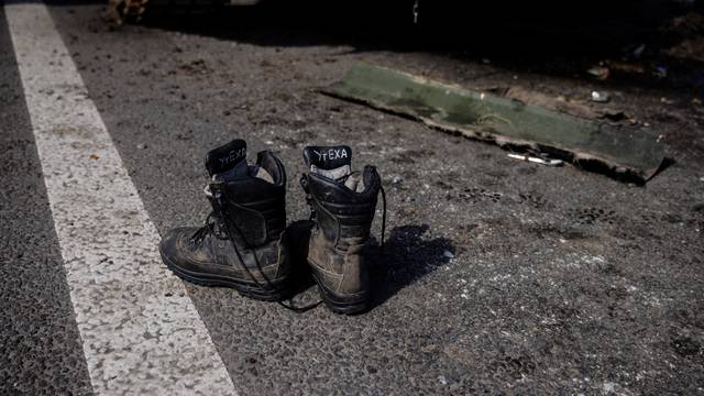 Boots of a Russian soldier are seen outside a Russian artillery vehicle that Ukraine captured during fighting outside Kharkiv