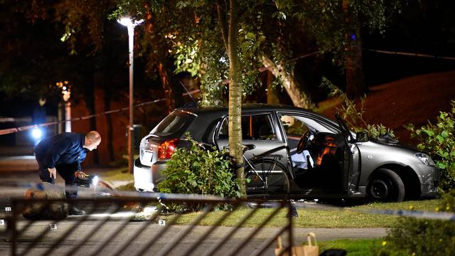 Police technicians examine the car which people who were injured were traveling in, after a shooting in southern Malmo