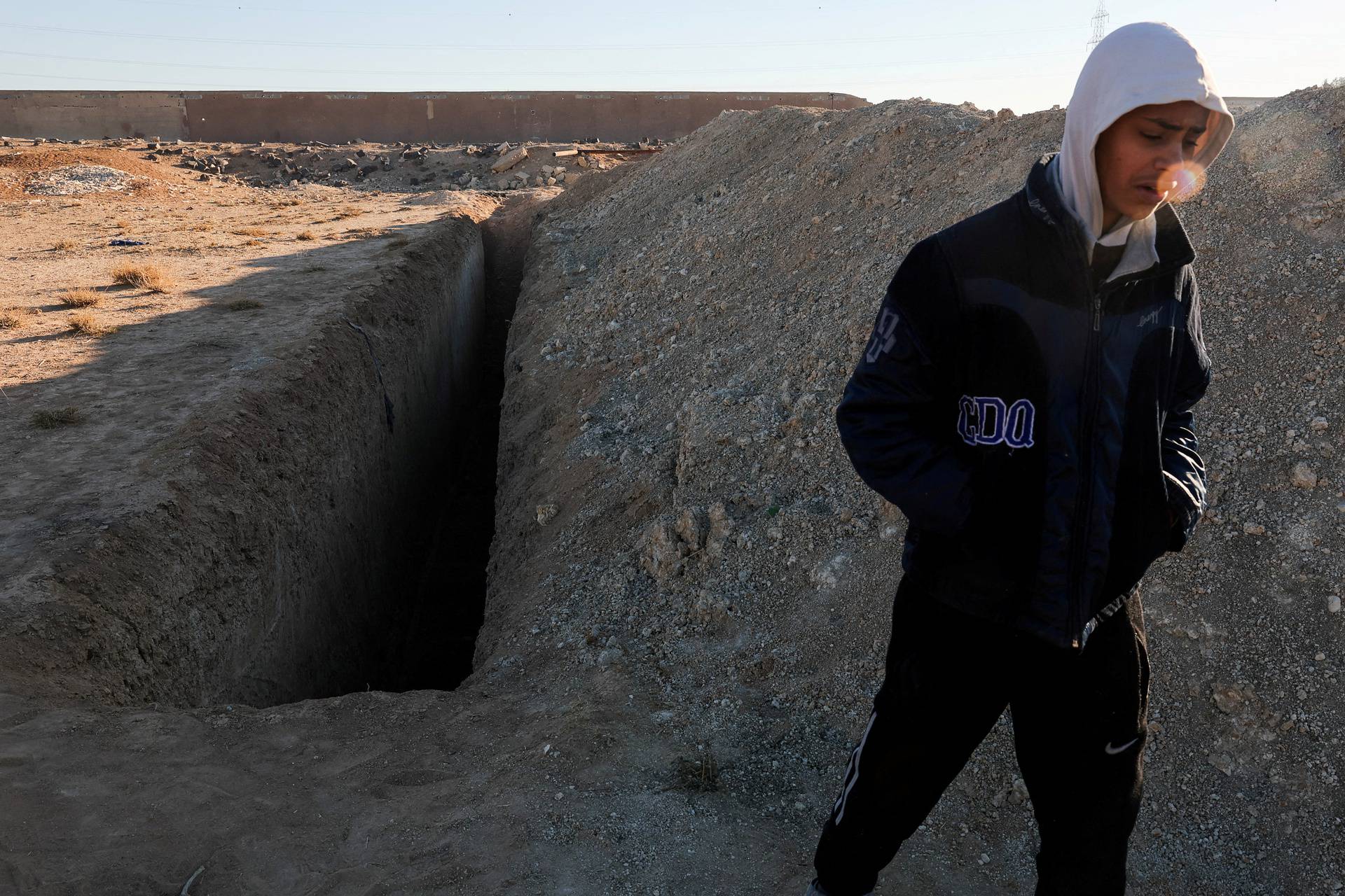 People inspect the site of a mass grave from under the rule of Syria's Bashar al-Assad, in Najha