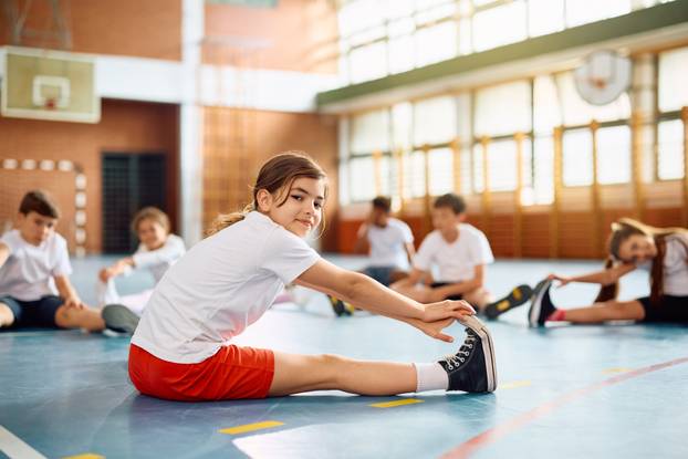 Smiling,Girl,And,Her,Classmates,Doing,Stretching,Exercises,During,Pe