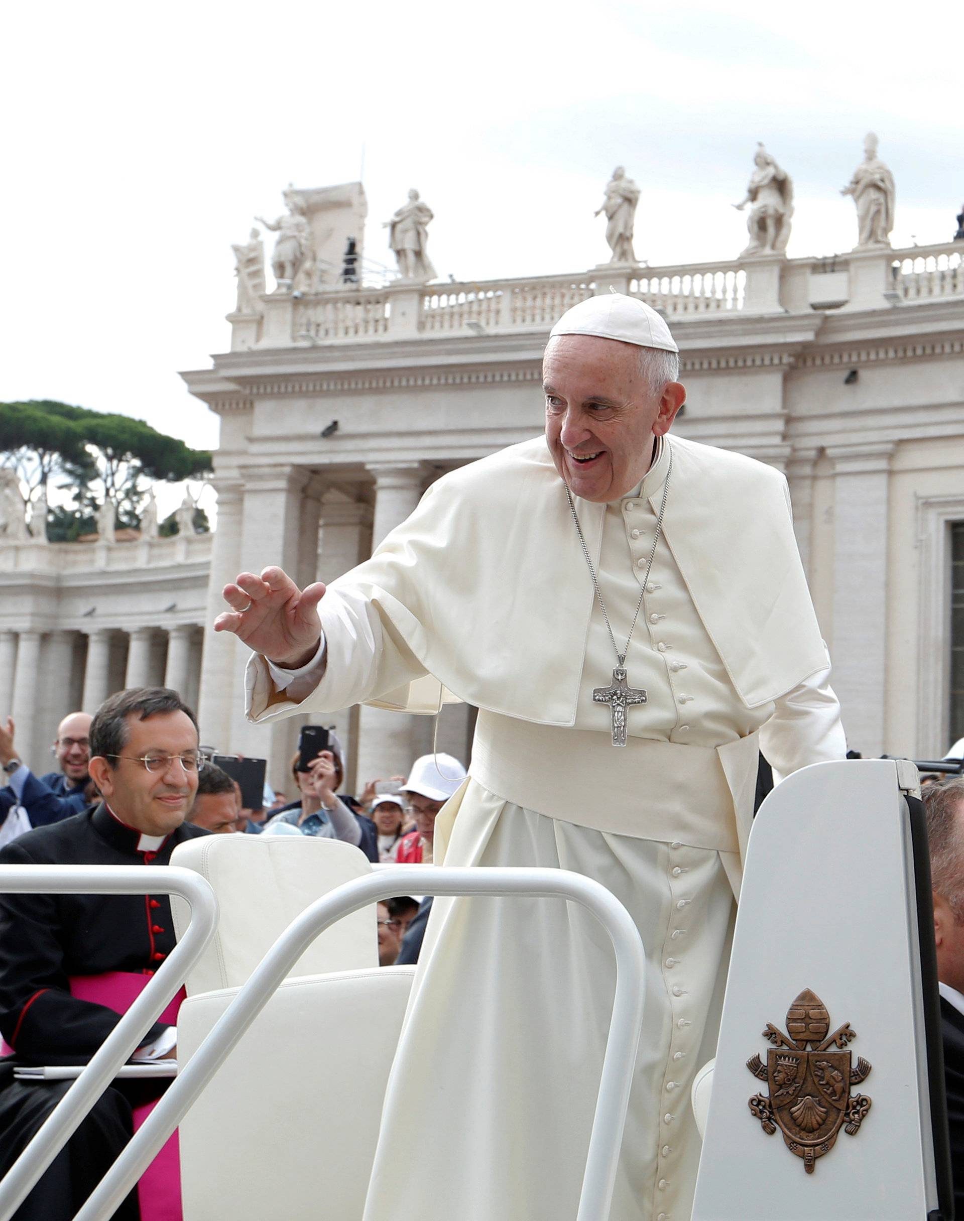 Pope Francis waves as he arrives to lead the Wednesday general audience in Saint Peter's square at the Vatican
