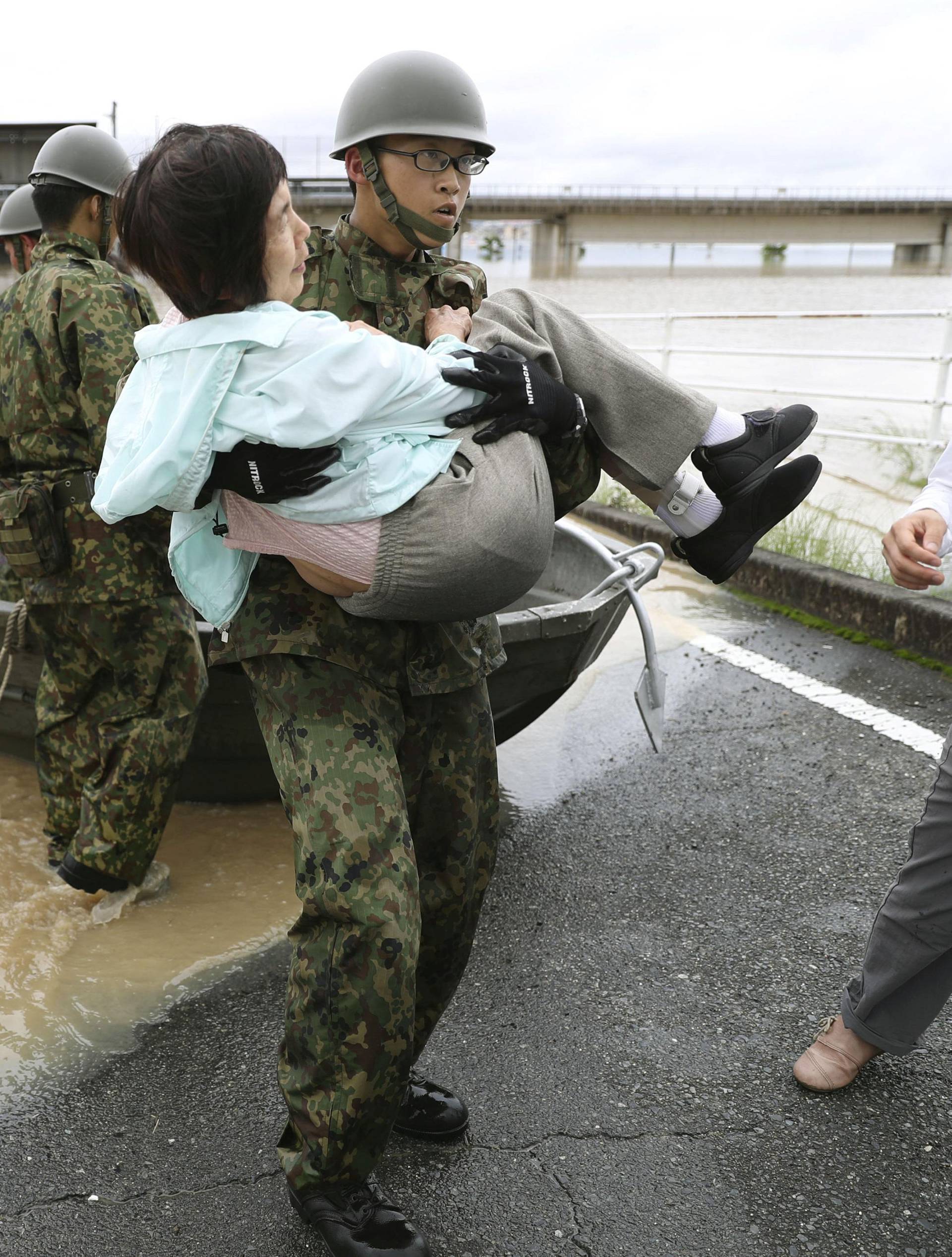Residents are rescued from a flooded area by Japan Self-Defense Force soldiers in Kurashiki