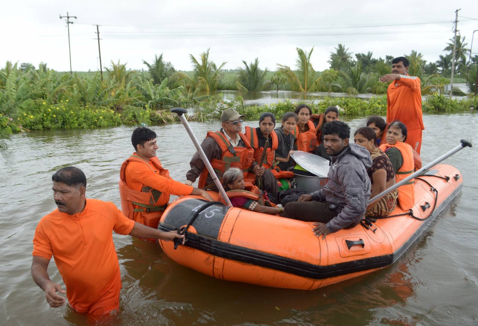 Members of National Disaster Response Force evacuate flood-affected people to a safer place, in Sangliwadi in Sangli district