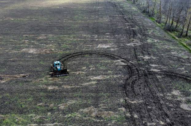 Remote controlled demining machine made of tractor and armoured plates from destroyed Russian military vehicles is seen in a field near the village of Hrakove