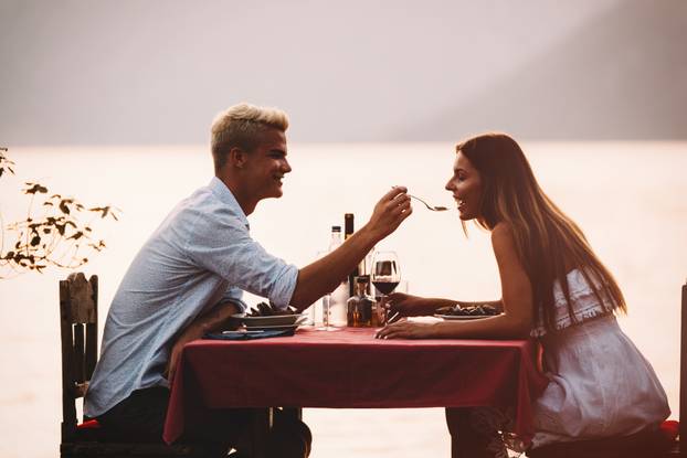 Happy couple on summer evening having romantic dinner outdoor