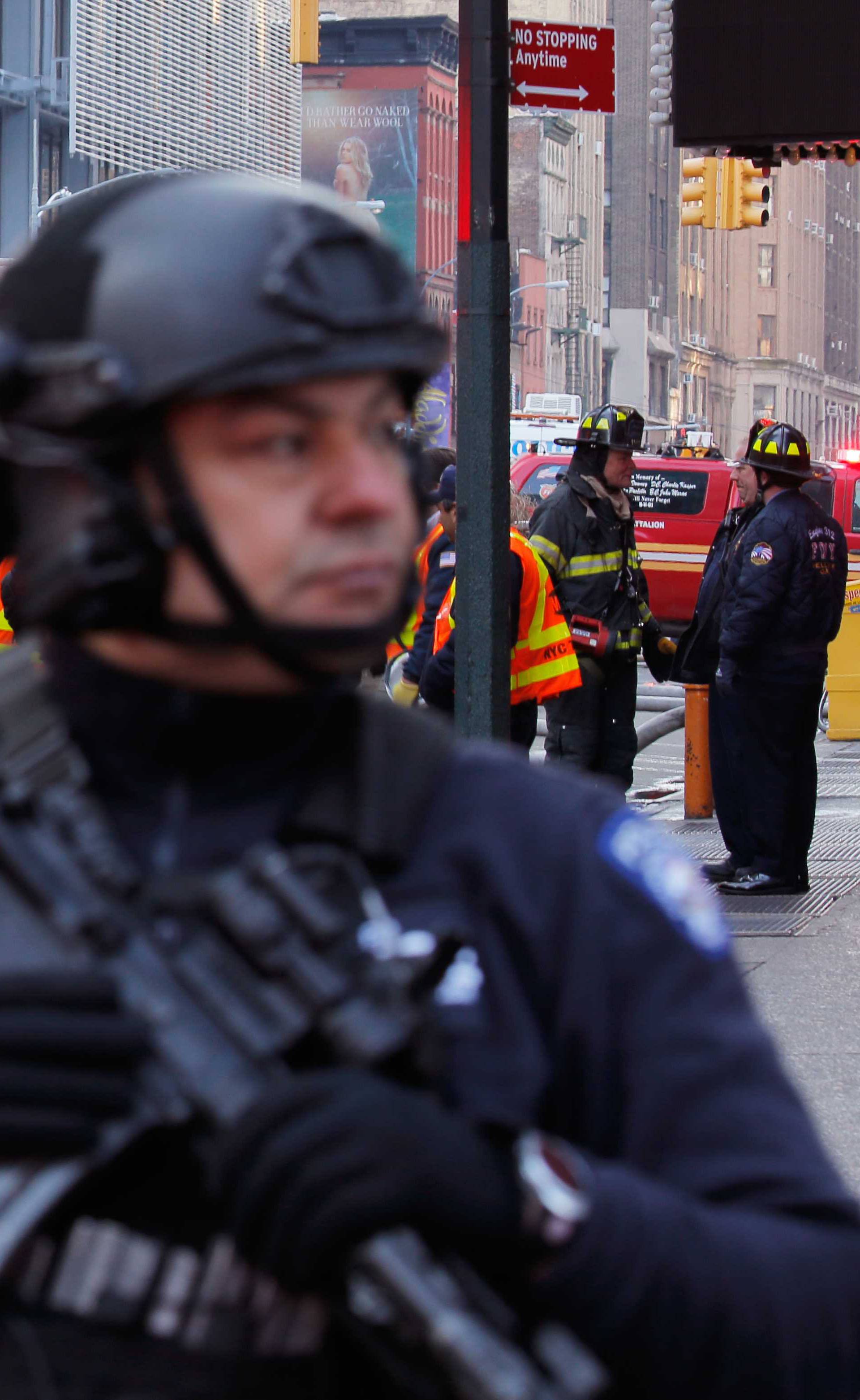 Police officers and fire crew stand outside the New York Port Authority Bus Terminal in New York City after reports of an explosion.