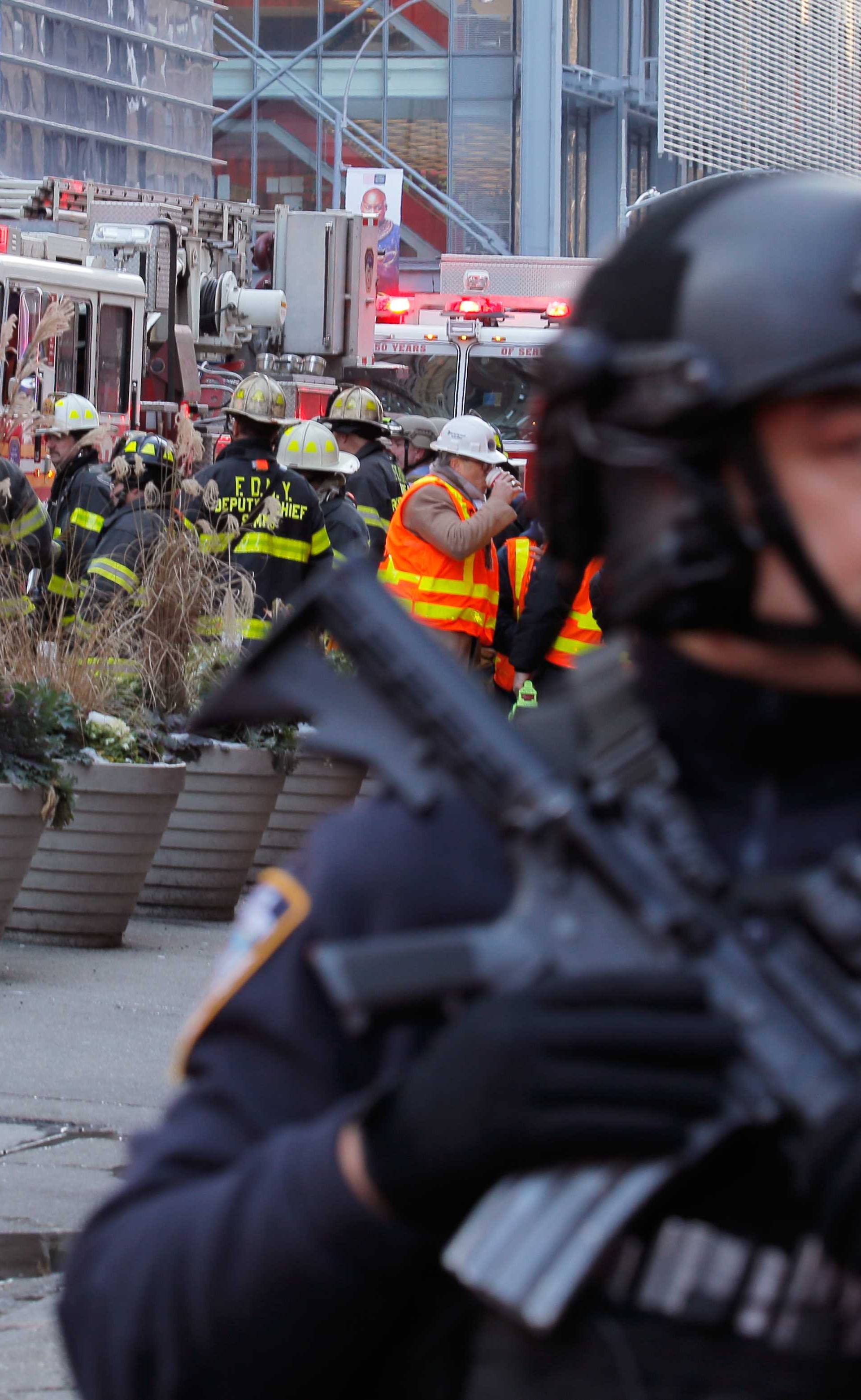 Police officers and fire crew stand outside the New York Port Authority Bus Terminal in New York City after reports of an explosion.