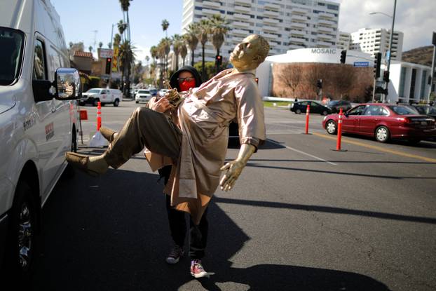 Artist Plastic Jesus sits on his statue of Harvey Weinstein on a casting couch on Hollywood Boulevard near the Dolby Theatre during preparations for the Oscars in Hollywood, Los Angeles
