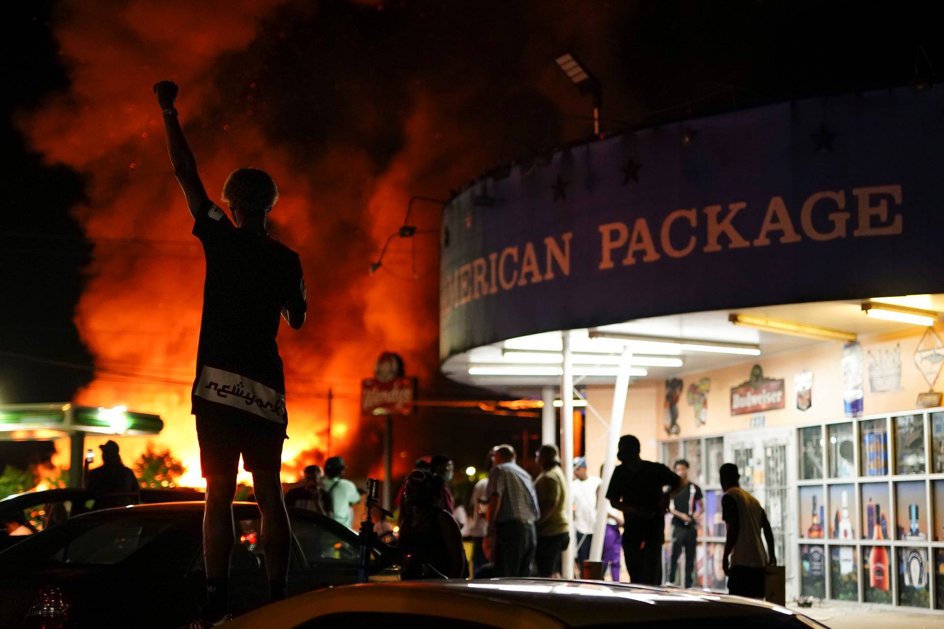 A protester watches as a Wendy’s burns following a rally against racial inequality and the police shooting death of Rayshard Brooks, in Atlanta