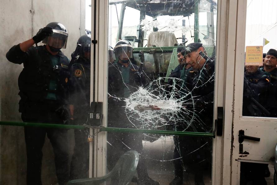 Spanish Civil Guard officers break through a door at a polling station for the banned independence referendum where Catalan President Puigdemont was supposed to vote in Sant Julia de Ramis