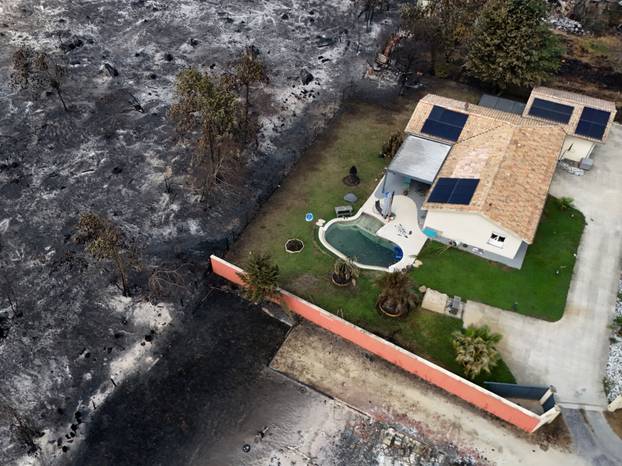 A drone view shows a house that withstood fire damage in an area affected by wildfire, in Le Porge