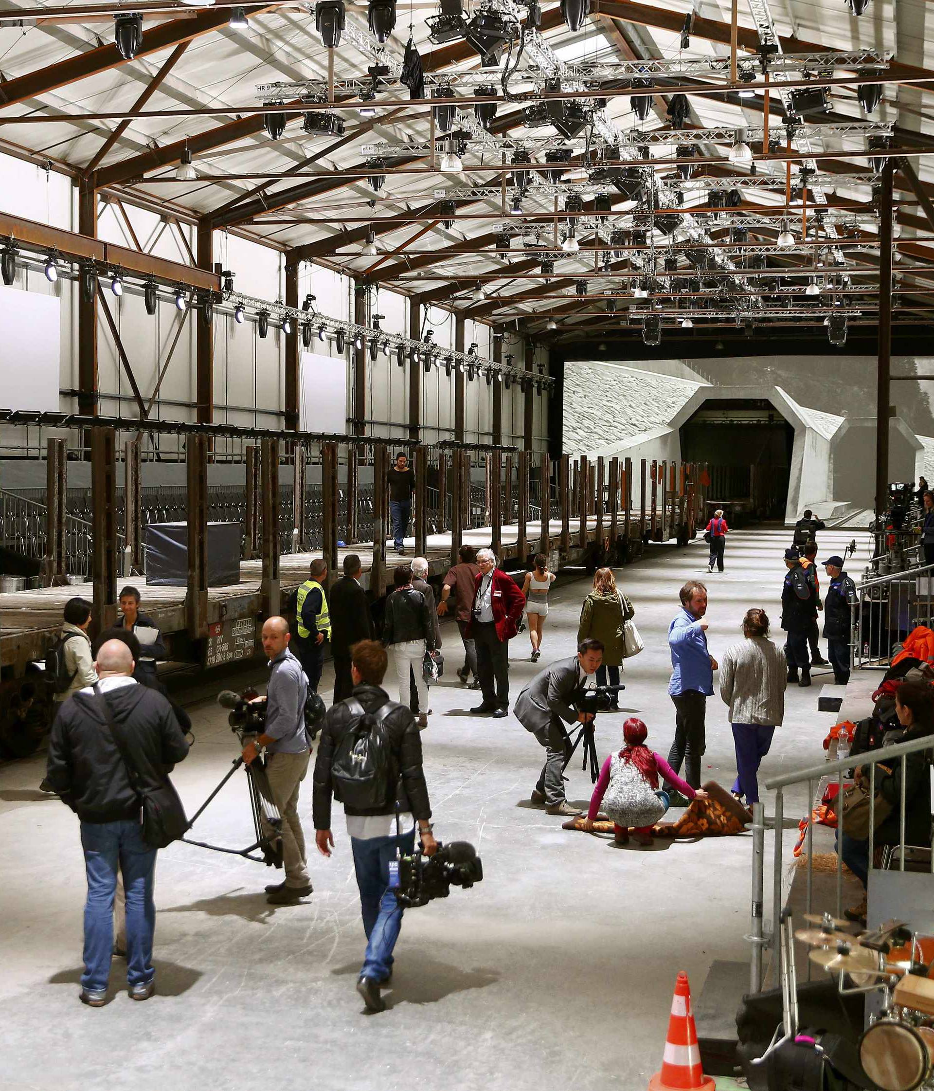 Journalists stand in front of mock gates of the NEAT Gotthard Base Tunnel inside the event hall for the upcoming opening ceremony near the town of Erstfeld