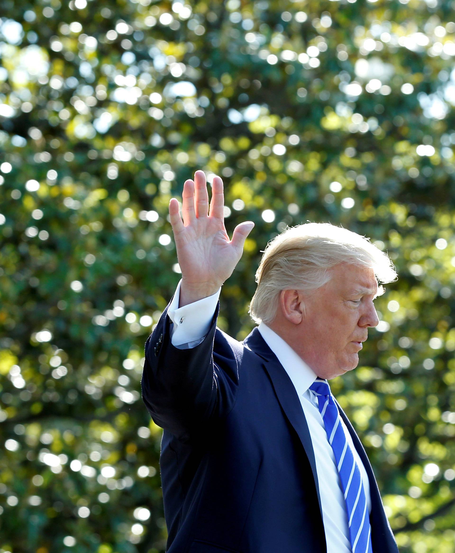 FILE PHOTO: U.S. President Donald Trump waves as he walks on the South Lawn of the White House in Washington