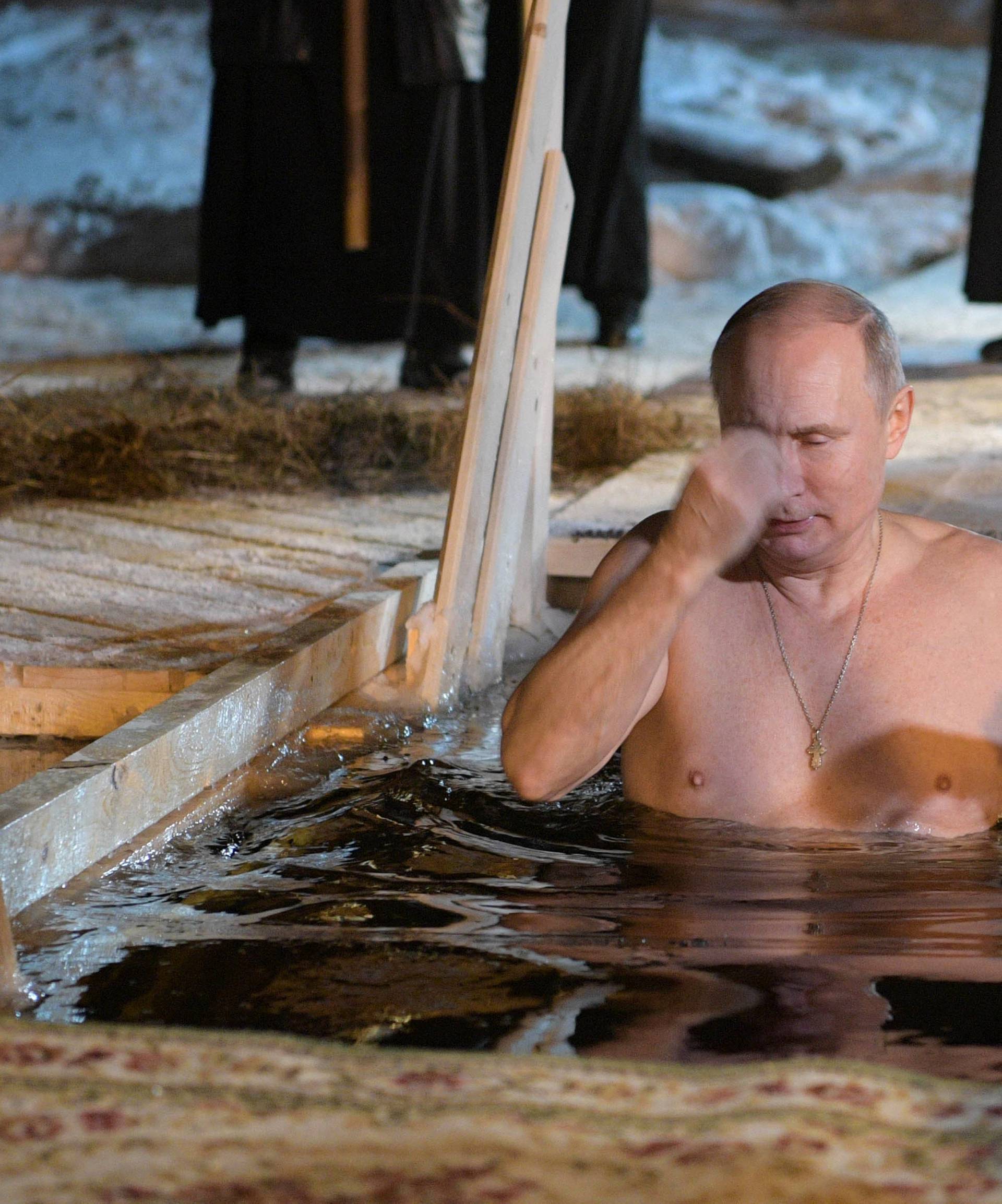 Russian President Vladimir Putin croses himself as he takes a dip in the water during Orthodox Epiphany celebrations at lake Seliger, Tver region
