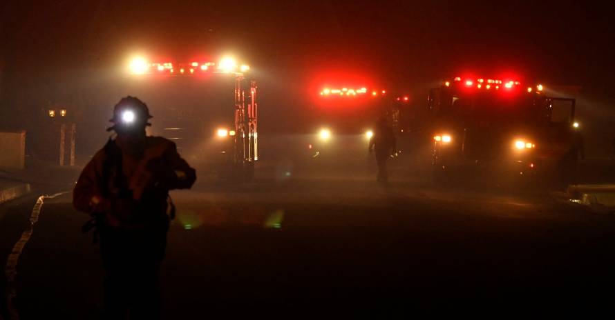 Firefighters battle a wind-driven wildfire called the Saddle Ridge fire in the early morning hours Friday in Porter Ranch