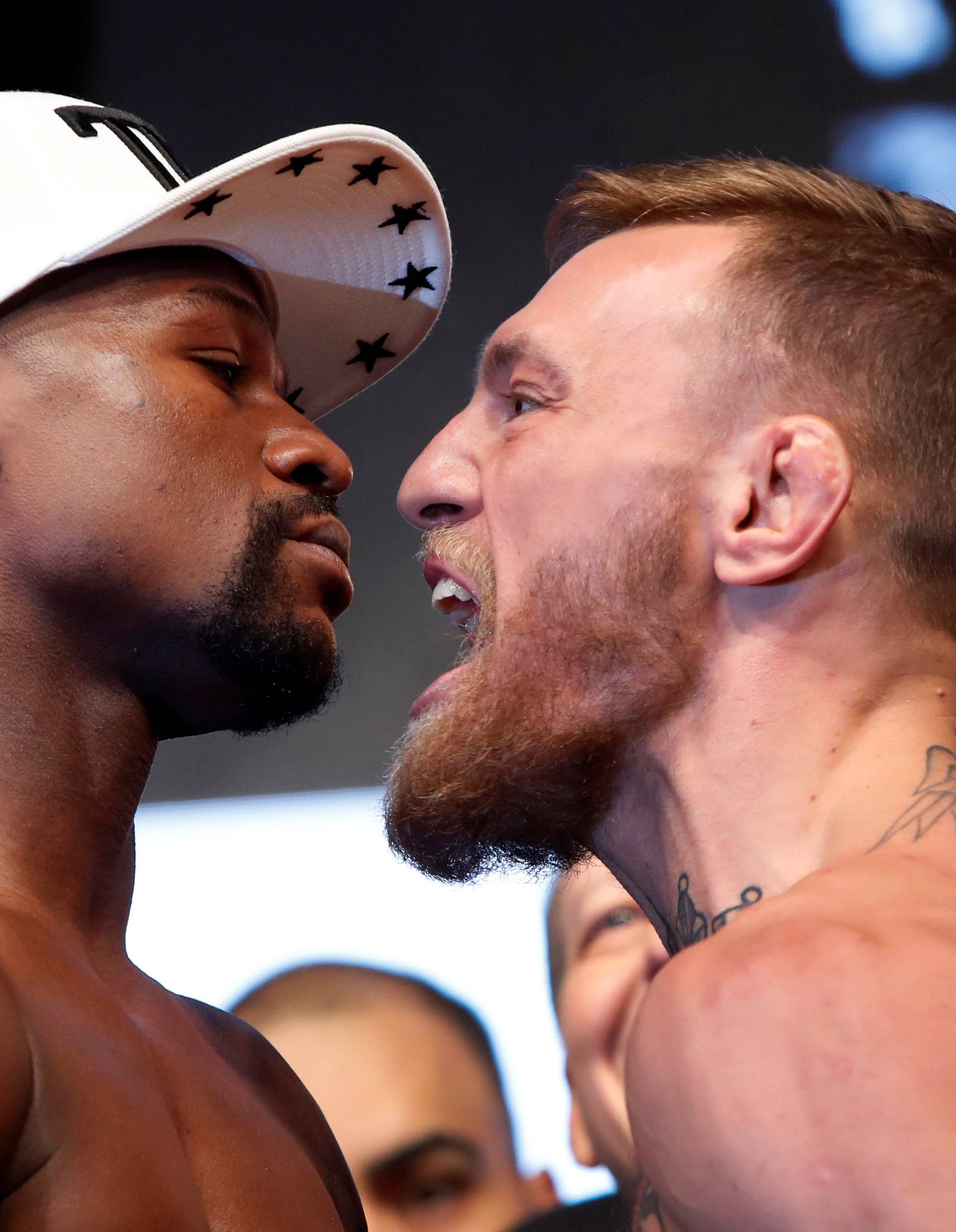 Undefeated boxer Floyd Mayweather Jr. (L) of the U.S. and UFC lightweight champion Conor McGregor of Ireland face off during their official weigh-in at T-Mobile Arena in Las Vegas