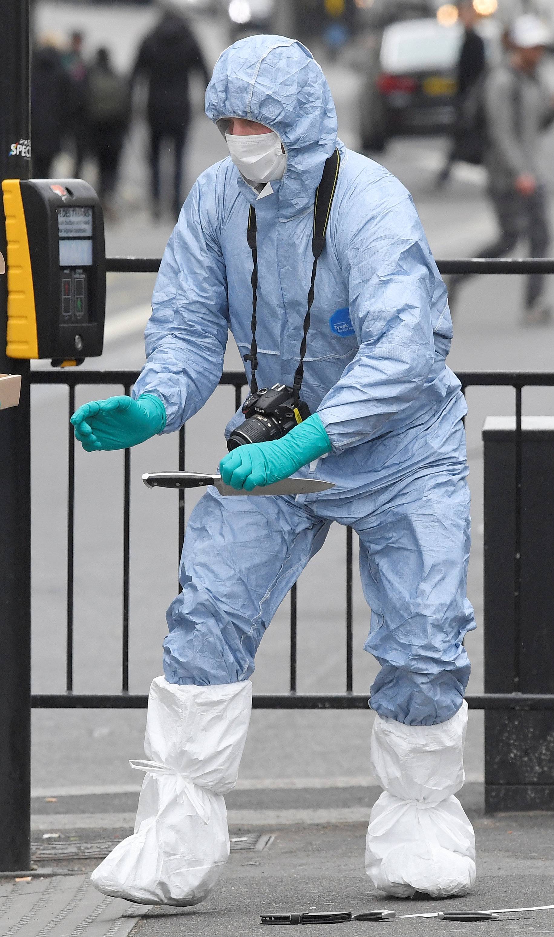 A forensic investigator recovers a knife after man was arrested on Whitehall in Westminster, central London