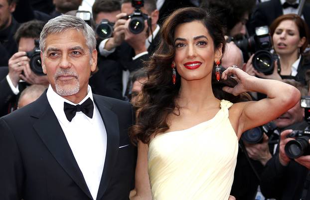Cast member George Clooney and his wife Amal pose on the red carpet as they arrive for the screening of the film "Money Monster" out of competition during the 69th Cannes Film Festival in Cannes