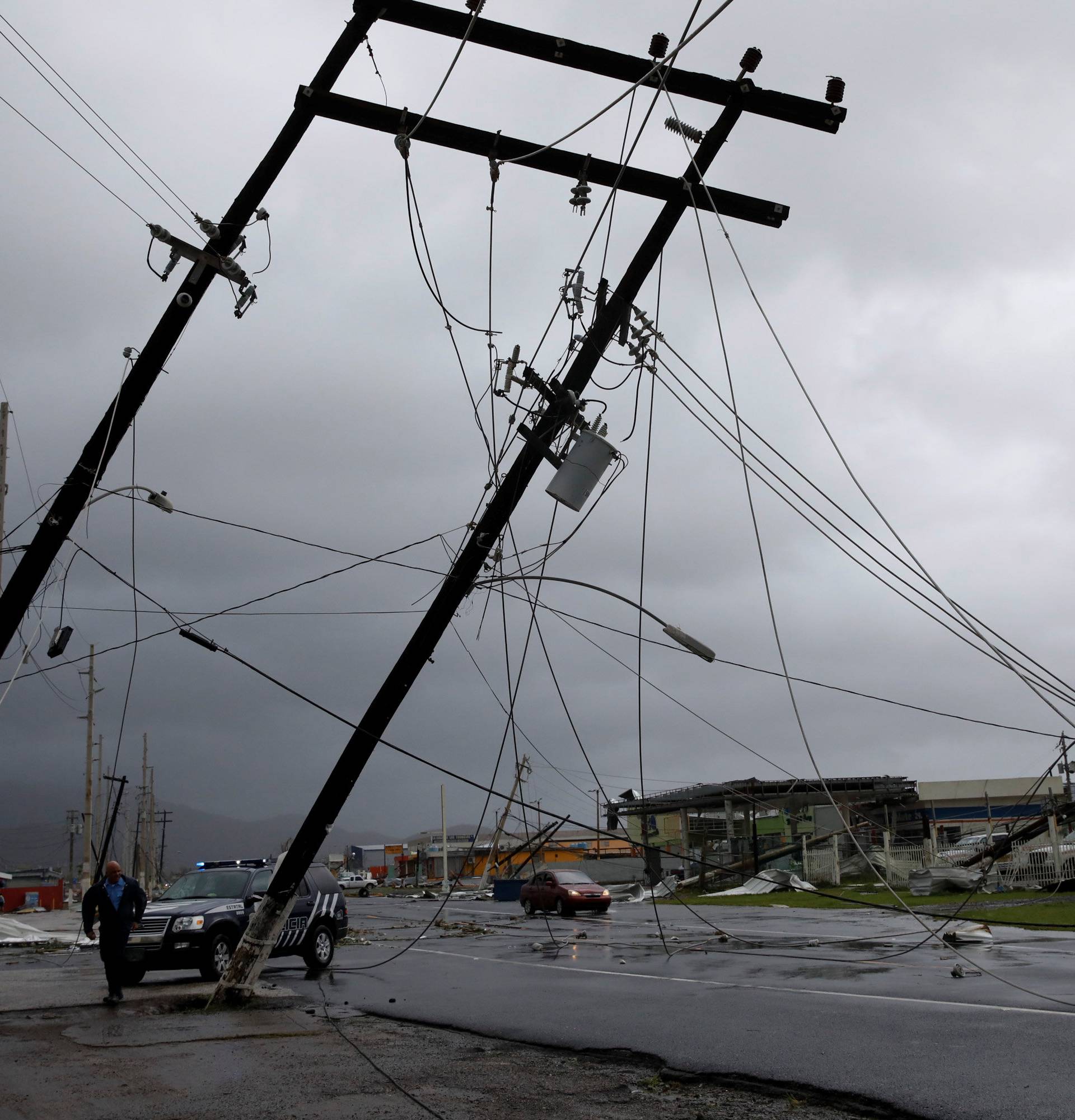 A police officer walks next to damaged electrical installations after the area was hit by Hurricane Maria en Guayama