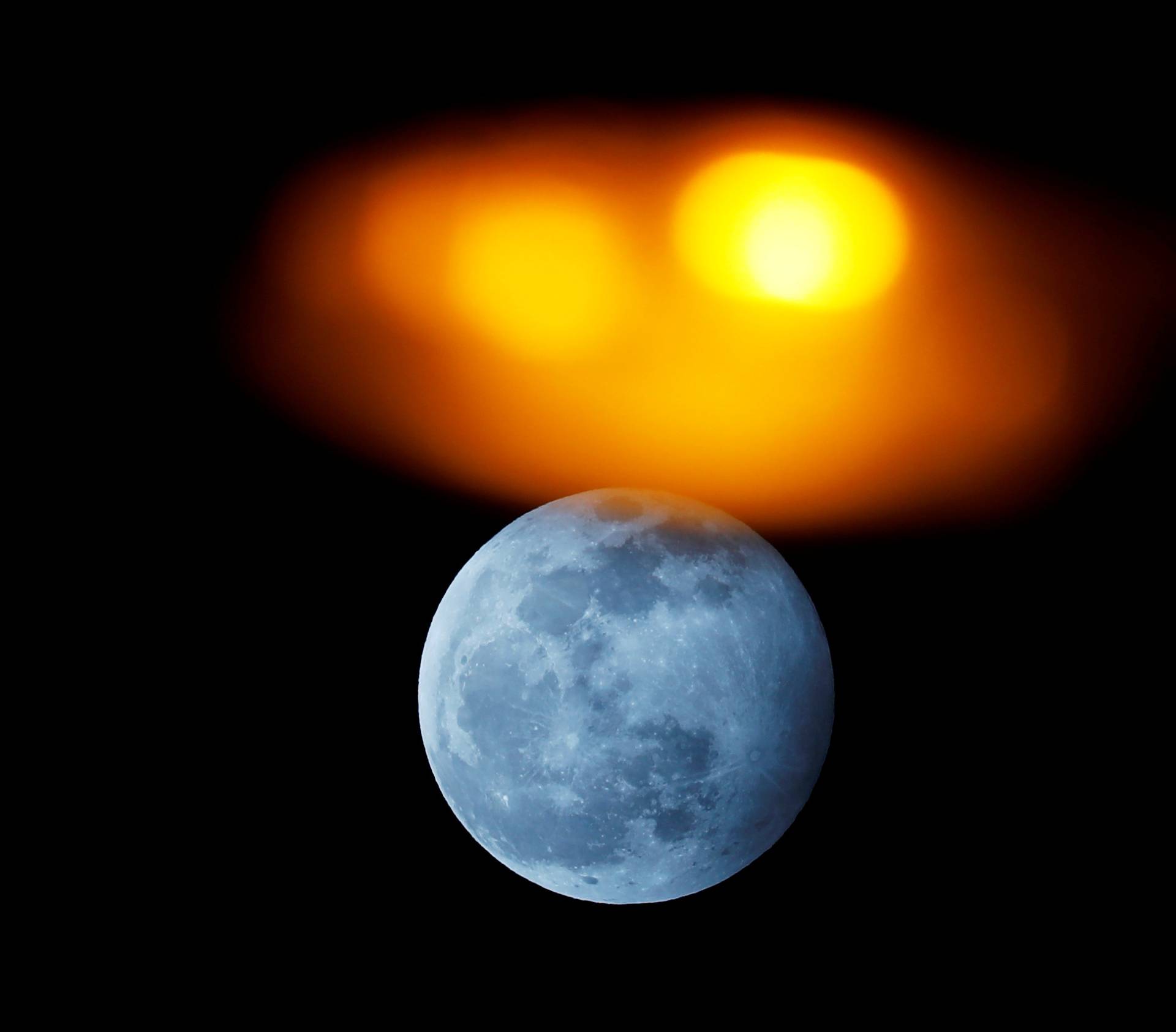 The full moon is seen rising behind a street light during the penumbral lunar eclipse in Ronda, Spain