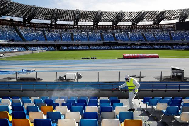 A cleaner wearing a protective suit sanitises seats at the San Paolo stadium ahead of the second leg of the Coppa Italia semi-final between Napoli and Inter Milan, which has since been postponed