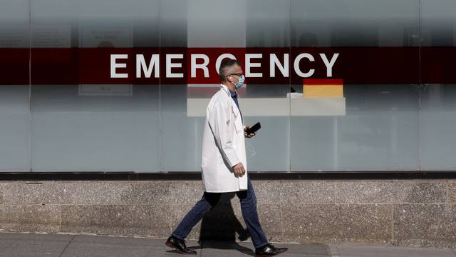 A doctor wears a protective mask as he walks outside Mount Sinai Hospital during the outbreak of coronavirus disease (COVID-19) in New York