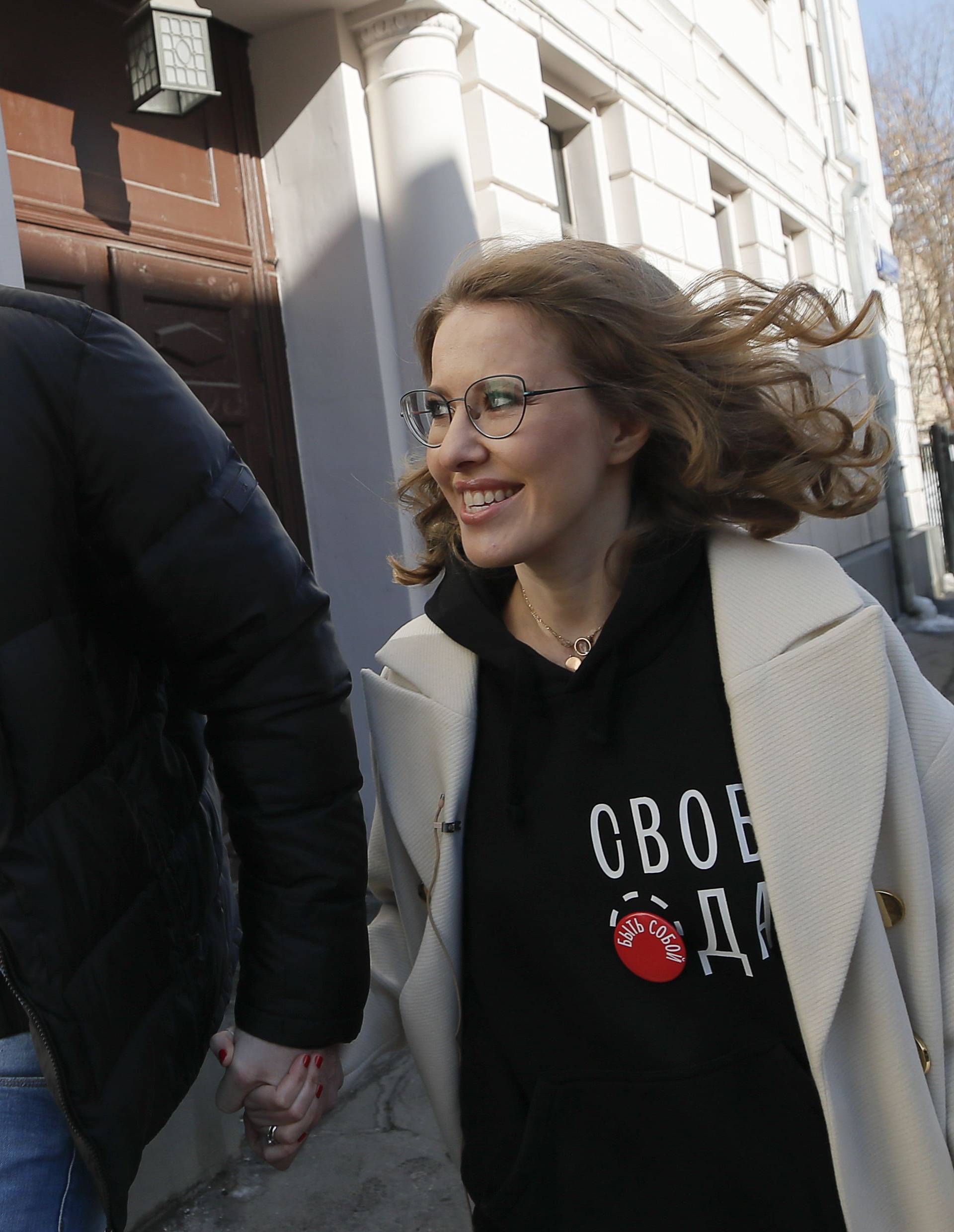 Presidential candidate Sobchak and her husband Vitorgan walk after visiting a polling station during the presidential election in Moscow