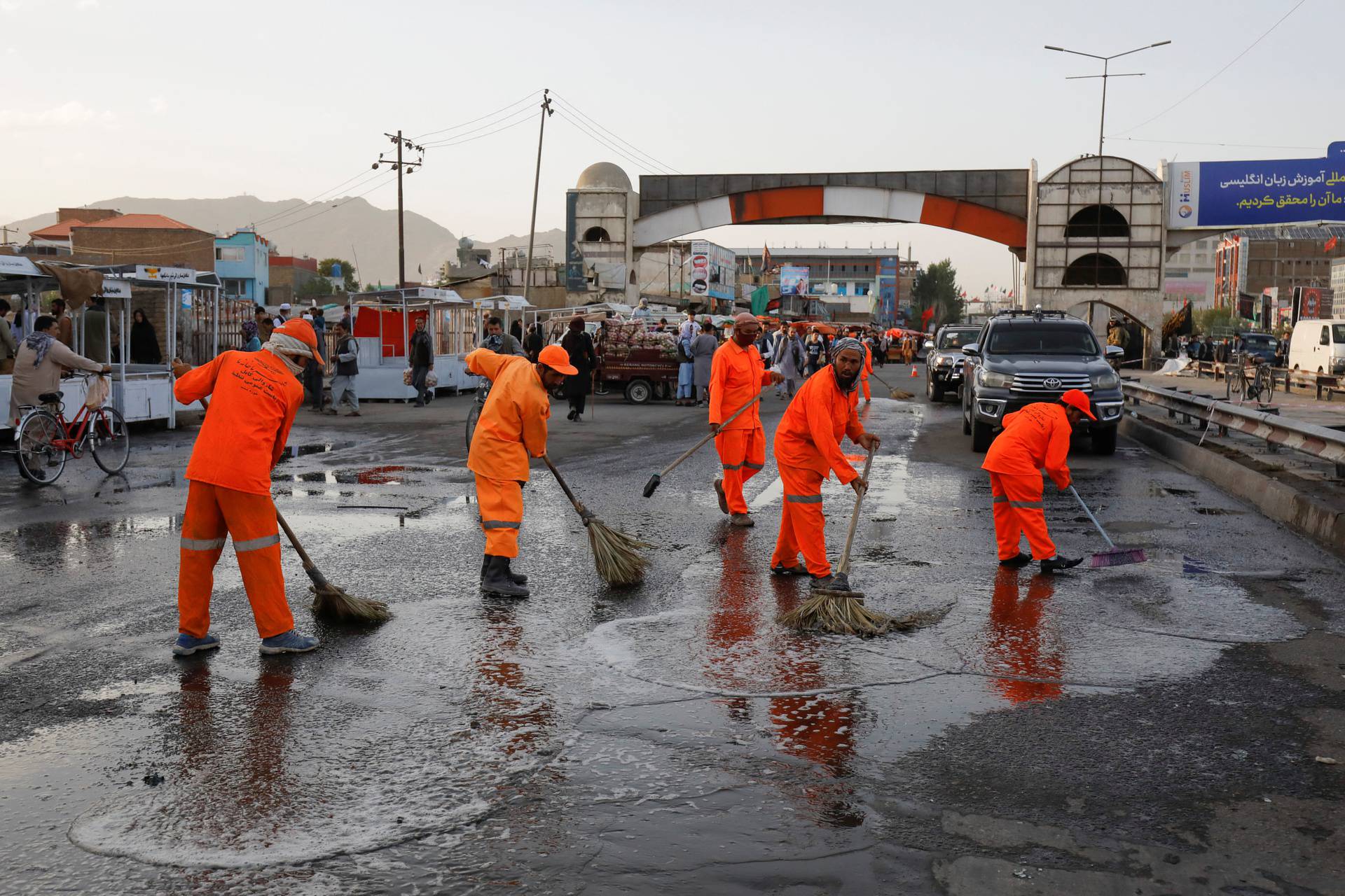 Municipality workers clean the blast site in Kabul