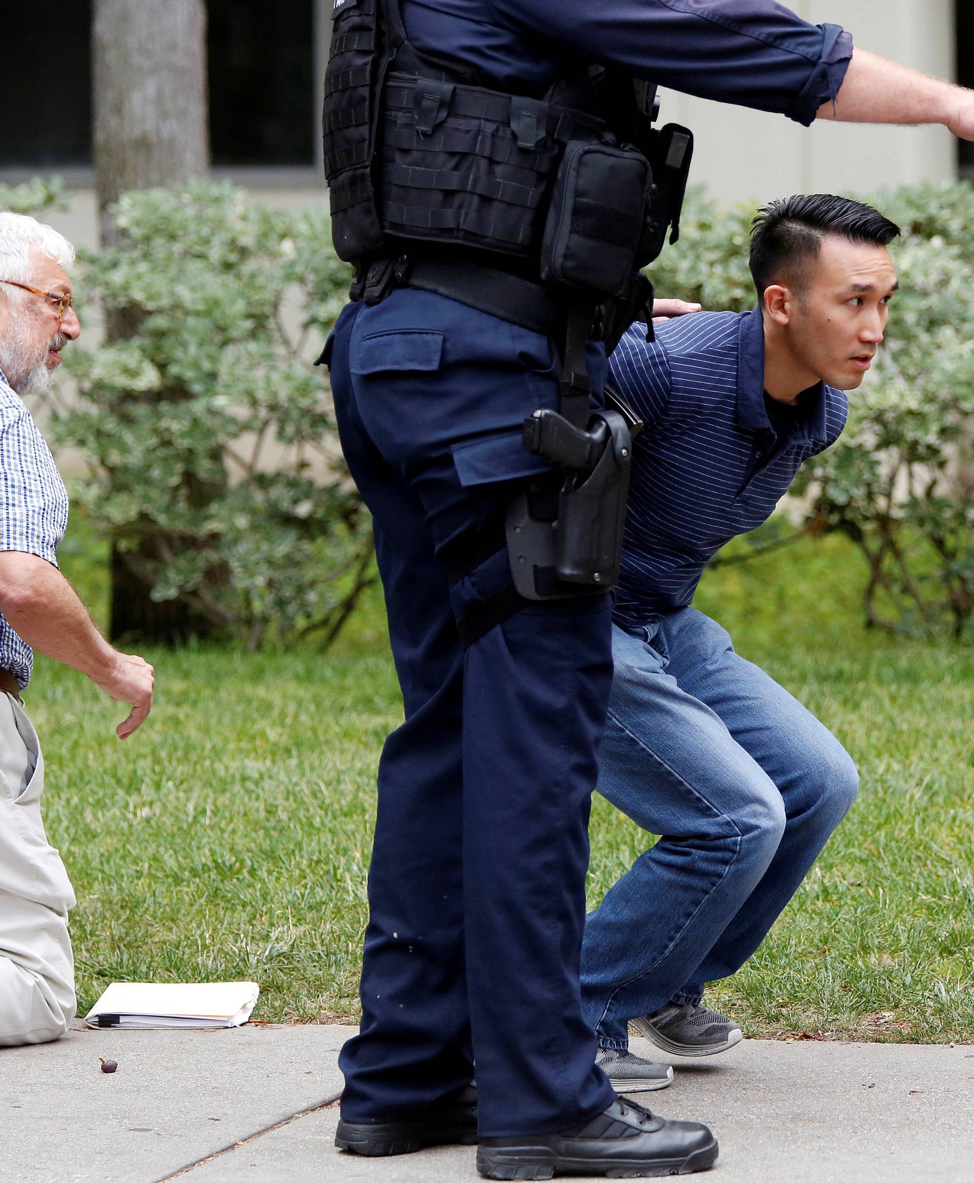 Police officers conduct a search at the UCLA campus after it was placed on lockdown following reports of a shooter that left 2 people dead in Los Angeles, California