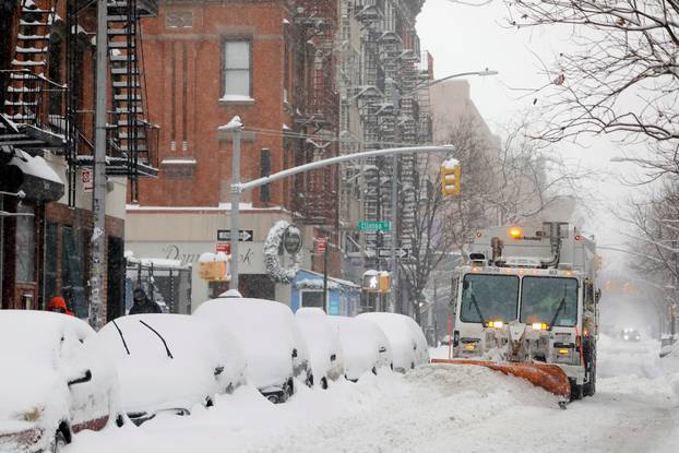 A snow plow clears a street during a snow storm in New York