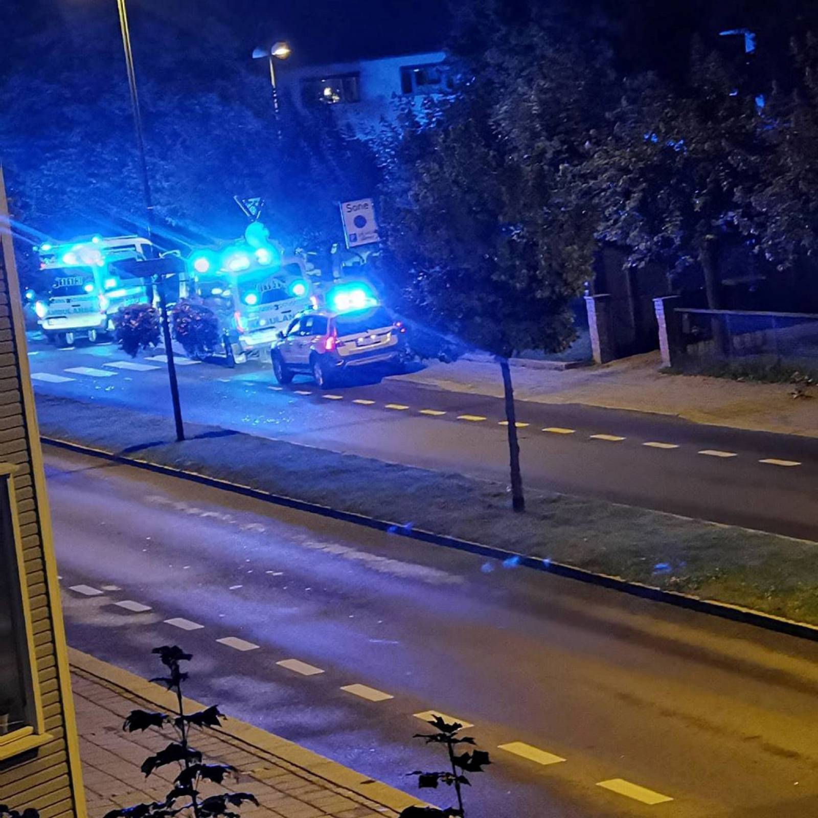 Police and emergency services are parked at the side of the road after people were stabbed in several locations in Sarpsborg